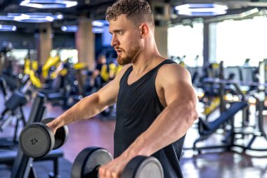 Sporcu salıncakta dambıllarla triseps sallıyor. Sağlıklı spor yaşam tarzı. Yüksek kalite fotoğraf