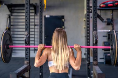 Sportif kız spor salonunda halterle egzersiz yapıyor. Spor sağlıklı yaşam tarzı konsepti. Yüksek kalite fotoğraf