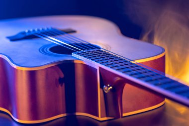 Gitar ve telleri sığ alan derinliğinde yakın çekim, yumuşak odaklanma. Profesyonel müzik enstrümanının ses deliği ve metal telleri.