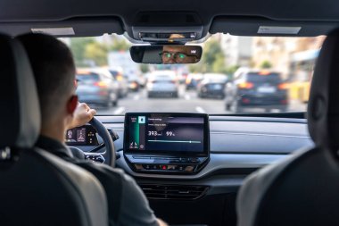 A male driver drives at speed through the streets of the city, a view from inside the car.