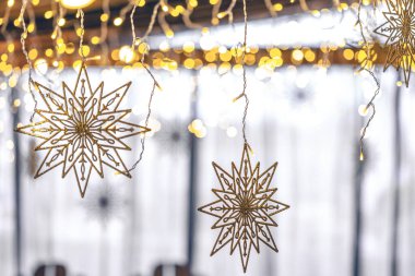 Bokeh ışıkları olan bulanık bir arka planda dekoratif kar taneleri ve çelenkler. Noel tatili dekoratif detayları iç kısımda..