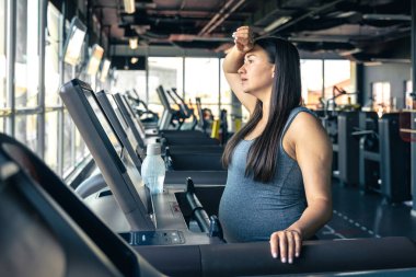Spor salonunda koşu bandında hamile bir kadın. Sağlıklı spor yaşam tarzı. - Evet. Yüksek kalite fotoğraf