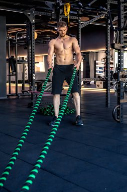 Ahlete çapraz halatla triseps egzersizleri yapıyor. Hobiler ve spor yaşam tarzı. - Evet. Yüksek kalite fotoğraf