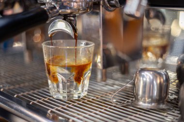 Kahve makinesinde bir baristanın kahvesini yapmak. Yüksek kalite fotoğraf. Makine kahveyi fincana çevirir. Yakın plan..