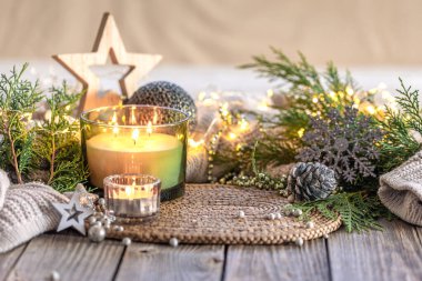 Samimi Noel kompozisyonu. Noel mumu. Yüksek kalite fotoğraf. Mumlu Noel arkaplanı. Uzayı kopyala Noel süslemeli mum. Tahta bir masada..