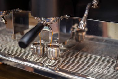 Kahve makinesinde bir baristanın kahvesini yapmak. Yüksek kalite fotoğraf. Makine kahveyi fincana çevirir. Yakın plan..