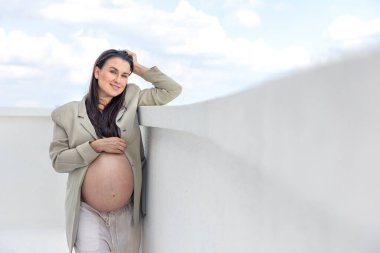 Ceket giyen şık hamile bir kadın. Tarz ve hamilelik kavramı. - Evet. Yüksek kalite fotoğraf