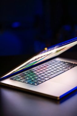 Karanlık arka planda yarı açık ekranı olan bir dizüstü bilgisayar. Uzayı kopyala Yüksek kalite fotoğraf. Modern dizüstü.