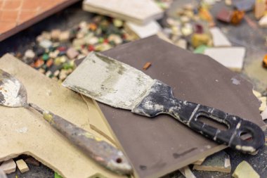 Sanat atölyesinde sanatsal palet bıçağı. Mozaik için fayanslar ve inşaat için Spatula. Yüksek kalite fotoğraf. Sanatçılar atölyesi. Fayansların arka planında yapı spatulası.