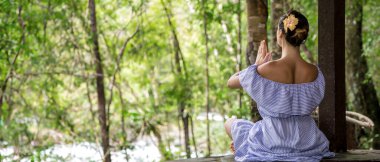 Kız doğada meditasyon yapıyor. Arkadan bak. Yüksek kalite fotoğraf. Mesaj için yer var. Doğanın arka planına karşı meditasyon yapan bir kız.