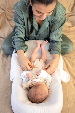 Yeni doğmuş bir bebeği olan genç bir anne. Yeni doğmuş bebek. Yüksek kalite fotoğraf. Yatakta yatıyor. Annelik. Anne ve bebek evde..