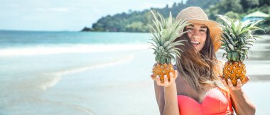 Egzotik bir sahilde ananaslı güzel bir kız. Denizde bir kadın. Yüksek kalite fotoğraf. Şapkalı bir kadın. Mesaj için yer. Denizin arka planında bir kadın.