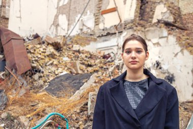 Savaş tarafından yıkılan bir evin yanındaki kız. Ukrayna 'da savaş. Yüksek kalite fotoğraf. Harabe içinde ağlayan genç bir kadın. Metin için boşluk.