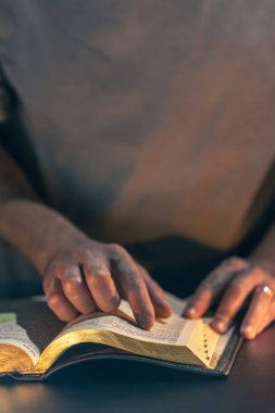 İncil okuyan bir adam. İncil 'e yakın çekimde erkek eli. Yüksek kalite fotoğraf. Din kavramı. Mesaj için yer var. Erkek eli İncil 'de.