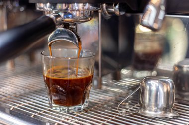 Kahve makinesinde bir baristanın kahvesini yapmak. Yüksek kalite fotoğraf. Makine kahveyi fincana çevirir. Yakın plan..