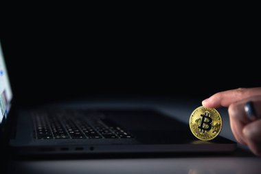 Siyah arka planda dizüstü bilgisayarın yanında Bitcoin para var. Finans ve kripto para konsepti. Yüksek kalite fotoğraf