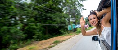 Gülümseyen kız taksinin camından dışarı bakar. Mesaj için yer. Yüksek kalite fotoğraf. Kadın arabadan dışarı bakmış. Bir kız seyahat eder.