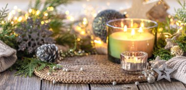 Samimi Noel kompozisyonu. Noel mumu. Yüksek kalite fotoğraf. Mumlu Noel arkaplanı. Uzayı kopyala Noel süslemeli mum. Tahta bir masada..