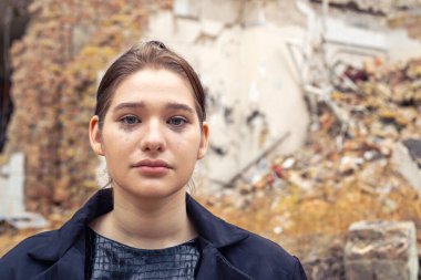 Savaş tarafından yıkılan bir evin yanındaki kız. Ukrayna 'da savaş. Yüksek kalite fotoğraf. Harabe içinde ağlayan genç bir kadın. Metin için boşluk.