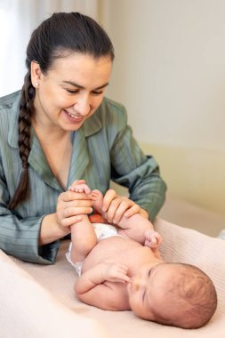 Yeni doğmuş bir bebeği olan genç bir anne. Yeni doğmuş bebek. Yüksek kalite fotoğraf. Yatakta yatıyor. Annelik. Anne ve bebek evde..