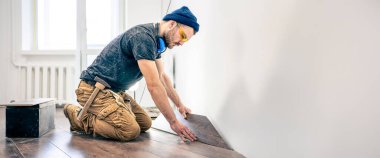 İnşaat işçisi. İşçi onarımlar yapar. Yüksek kalite fotoğraf. Mesaj için yer var. Koruyucu gözlüklü bir adam. Tamirci tamirat yapar..