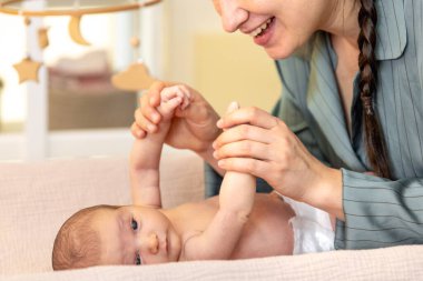 Yeni doğmuş bir bebeği olan genç bir anne. Yeni doğmuş bebek. Yüksek kalite fotoğraf. Yatakta yatıyor. Annelik. Anne ve bebek evde..