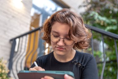 Yorgun genç kadın grafik tasarımcısı. Yorgun tasarımcı. Duygu konsepti. Yüksek kalite fotoğraf. Gözlüklü bir kız tablette grafik tasarımcısı olarak çalışıyor..