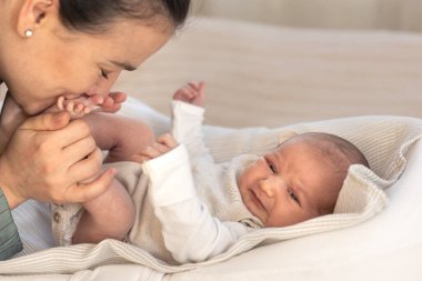Yeni doğmuş bir bebeği olan genç bir anne. Yeni doğmuş bebek. Yüksek kalite fotoğraf. Anne kızını öpüyor. Çocukluk. Annelik.