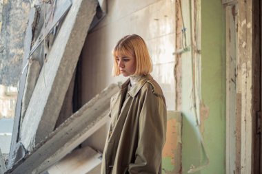 Savaş tarafından yıkılan bir evin yakınında bir kadın. Ukrayna 'da savaş. Ukraynalı mülteciler. Yüksek kalite fotoğraf. Barış kavramı. Kyiv 'de yıkılmış bir evin yanında üzgün bir kız..