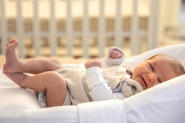 Yeni doğmuş bebek. Yeni doğmuş bebeğe yakın çekim. Yüksek kalite fotoğraf. Annelik. Yeni doğmuş bir bebek yatakta yatıyor. Evde yeni doğmuş bir bebek.