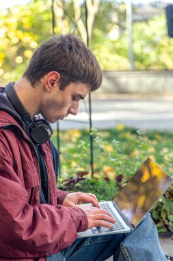 Bir öğrenci dizüstü bilgisayar kullanarak ders çalışıyor. İnternette okuyan erkek öğrenci. Öğrenme konsepti. Yüksek kalite fotoğraf. Üniversitede ya da üniversitede okuyan ve dizüstü bilgisayarda ödev yapan genç bir öğrenci..