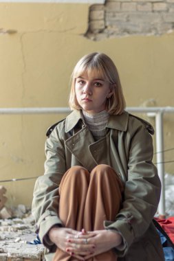 Savaş tarafından yıkılan bir evin yanında bir kadın. Ukrayna 'da savaş. Ukraynalı mülteciler. Yüksek kalite fotoğraf. Barış kavramı. Kyiv 'de yıkılmış bir evin yanında üzgün bir kız..