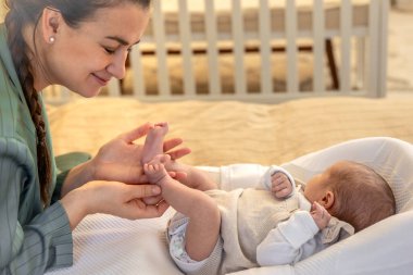 Yeni doğmuş bir bebeği olan genç bir anne. Yeni doğmuş bebek. Yüksek kalite fotoğraf. Yatakta yatıyor. Annelik. Anne ve bebek evde..