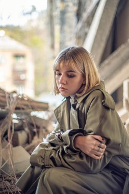 Savaş tarafından yıkılan bir evin yakınında bir kadın. Ukrayna 'da savaş. Ukraynalı mülteciler. Yüksek kalite fotoğraf. Barış kavramı. Kyiv 'de yıkılmış bir evin yanında üzgün bir kız..