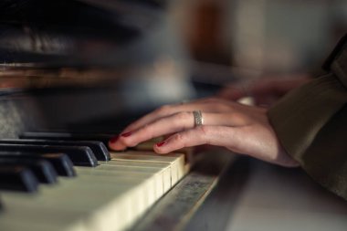 Piyanoda kadın eli var. Piyano çalan kadın eller. Yüksek kalite fotoğraf. Kadın eli piyano tuşuna basıyor, yakın plan. Klasik piyano çalıyorum..