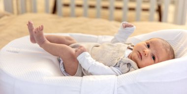 Yeni doğmuş bebek. Yeni doğmuş bebeğe yakın çekim. Yüksek kalite fotoğraf. Annelik. Yeni doğmuş bir bebek yatakta yatıyor. Evde yeni doğmuş bir bebek.