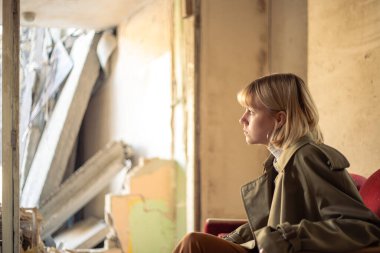 Savaş tarafından yıkılan bir evin yanında bir kadın. Ukrayna 'da savaş. Ukraynalı mülteciler. Yüksek kalite fotoğraf. Barış kavramı. Kyiv 'de yıkılmış bir evin yanında üzgün bir kız..