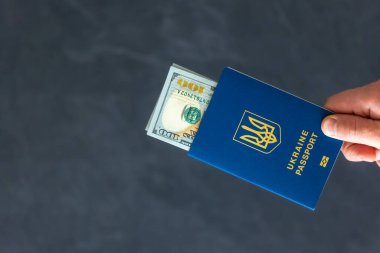 Pasaportlar, para değişimi. Ukrayna pasaportu. Göç kavramı. Yüksek kalite fotoğraf. Pasaportlar, para değişimi. Ukrayna pasaportu ve doları tutan erkek eller..