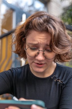 Yorgun genç kadın grafik tasarımcısı. Yorgun tasarımcı. Duygu konsepti. Yüksek kalite fotoğraf. Gözlüklü bir kız tablette grafik tasarımcısı olarak çalışıyor..