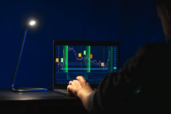 Trading stock. Stock market. Business graph. Trading investment. Broker. Stock exchange market. High quality photo. Hands on laptop, investments. The lamp shines in the dark.