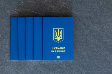 Ukrayna pasaportları istiflenmiş. Ukrayna biyometrik pasaportu. Göç kavramı. Ukrayna pasaportu yakın plan. Karanlık bir arka planda. Ukrayna pasaportlu seyahat konsepti. Metin için boşluk.