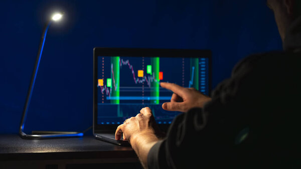Trading stock. Stock market. Business graph. Trading investment. Broker. Stock exchange market. High quality photo. Hands on laptop, investments. The lamp shines in the dark.