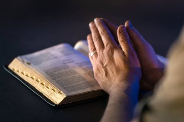 İncil 'in üzerine yemin ederim. Dua et. İncil 'i yakın plan aç. Din kavramı. Yüksek kalite fotoğraf. Hıristiyanlık, dua ve İncil okuma.