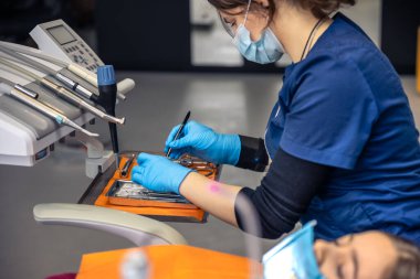 İşte bir dişçi. Çocuk dişini tedavi eden genç bir dişçi. Dişçi konsepti. Yüksek kalite fotoğraf. Dişçi muayenehanesi. Diş hekimi çocuk hastalarının dişlerini muayene ediyor..