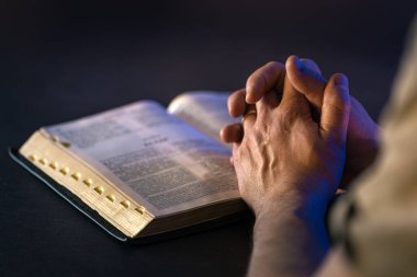 İncil 'in üzerine yemin ederim. Dua et. İncil 'i yakın plan aç. Din kavramı. Yüksek kalite fotoğraf. Hıristiyanlık, dua ve İncil okuma.