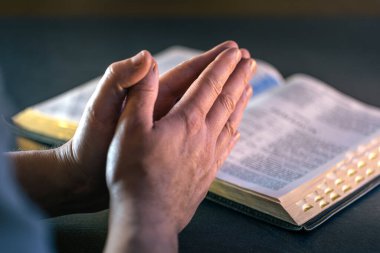 İncil 'in üzerine yemin ederim. Dua et. İncil 'i yakın plan aç. Din kavramı. Yüksek kalite fotoğraf. Hıristiyanlık, dua ve İncil okuma.