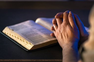 İncil 'in üzerine yemin ederim. Dua et. İncil 'i yakın plan aç. Din kavramı. Yüksek kalite fotoğraf. Hıristiyanlık, dua ve İncil okuma.