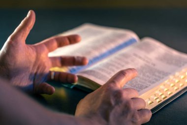 İncil 'in üzerine yemin ederim. Dua et. İncil 'i yakın plan aç. Din kavramı. Yüksek kalite fotoğraf. Hıristiyanlık, dua ve İncil okuma.