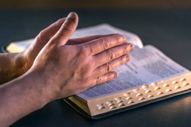 İncil 'in üzerine yemin ederim. Dua et. İncil 'i yakın plan aç. Din kavramı. Yüksek kalite fotoğraf. Hıristiyanlık, dua ve İncil okuma.