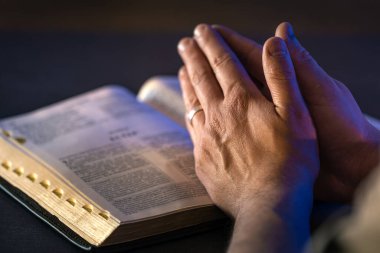 İncil 'in üzerine yemin ederim. Dua et. İncil 'i yakın plan aç. Din kavramı. Yüksek kalite fotoğraf. Hıristiyanlık, dua ve İncil okuma.